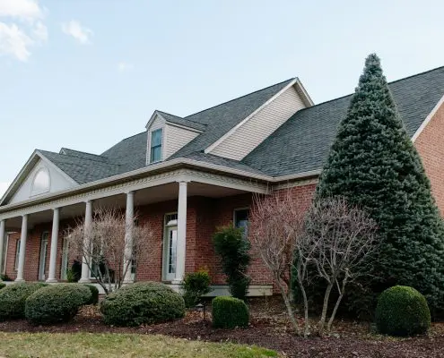 Brick Home With Shingle Roof & Gutters