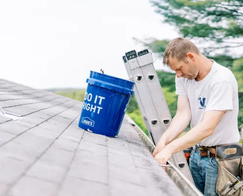 Valley Roofing & Exteriors worker cleaning gutters.