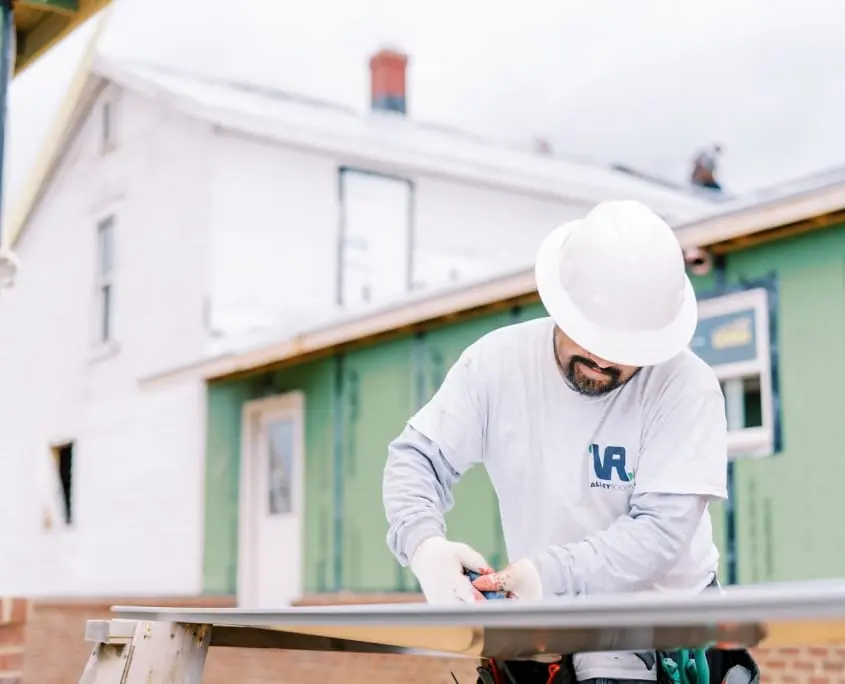 Warranty1 Roofers cutting material for metal roofing project on-site at Staunton home