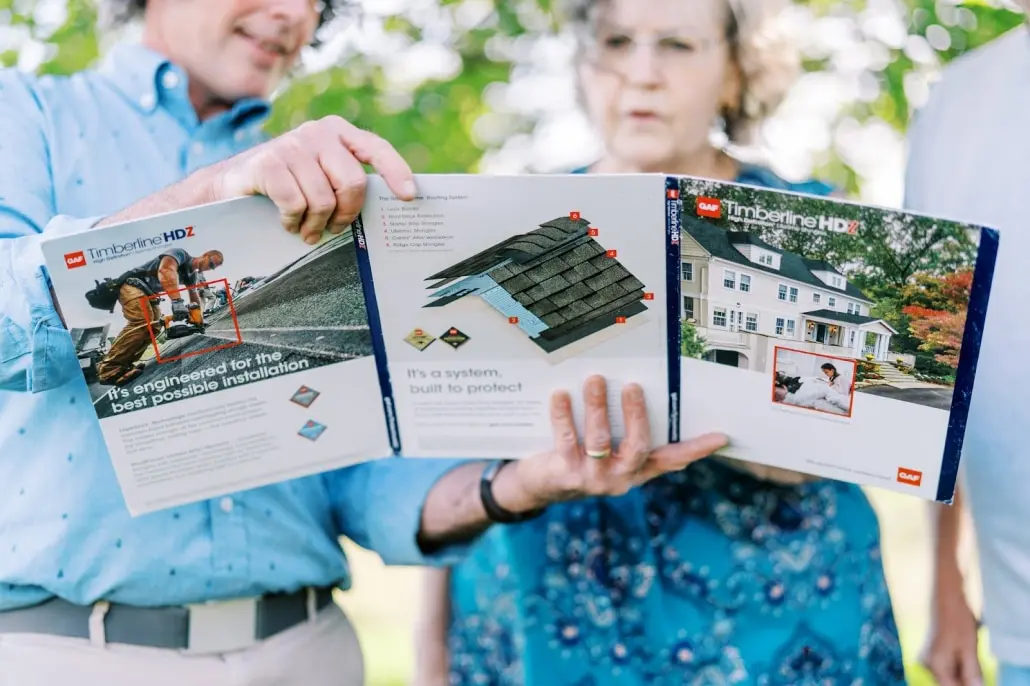 Warranty2 Roofers in Harrisonburg presenting a GAF brochure with warranty information to homeowners