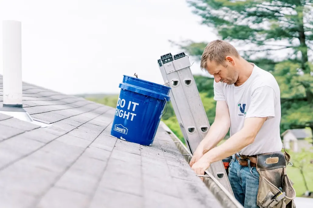 man cleaning gutters