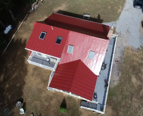 Red metal roofed house with skylights and gutters from above