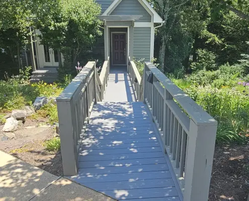 deck boards with railing leading to a home