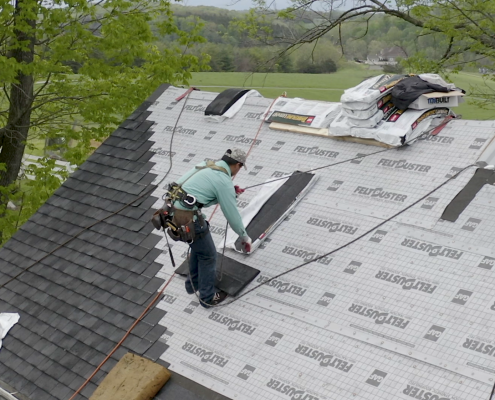 roofer puts shingles on house in the Shenandoah Valley
