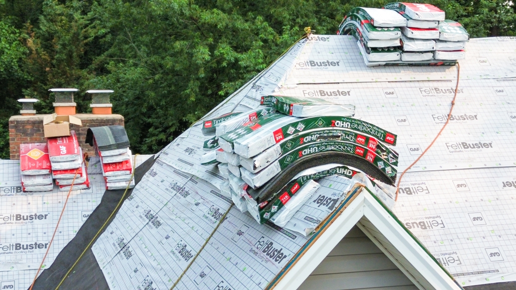 Stacks of GAF materials stacked on top of residential roof mid-way through installation