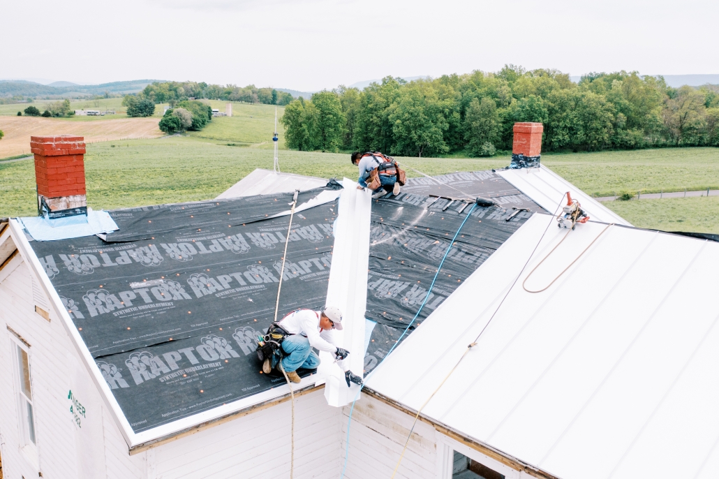 Valley Roofing roofers applying new metal roofing to a home.