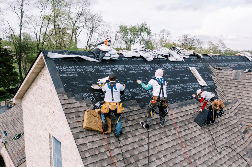 Valley Roofing roofers on a roof applying shingles.