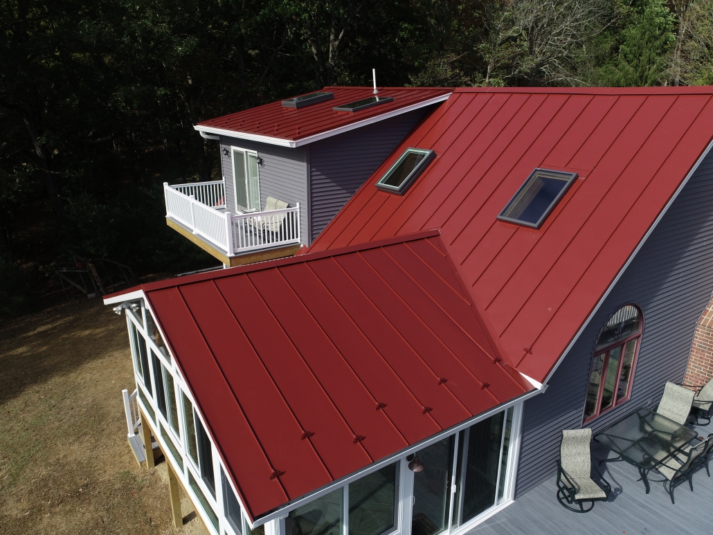 red metal roofing on home with porch and skylights