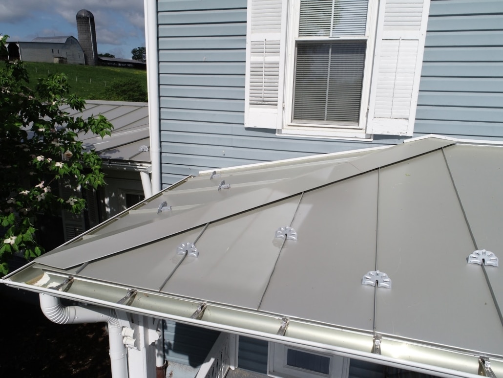Metal roofing and custom gutters featuring snow guards