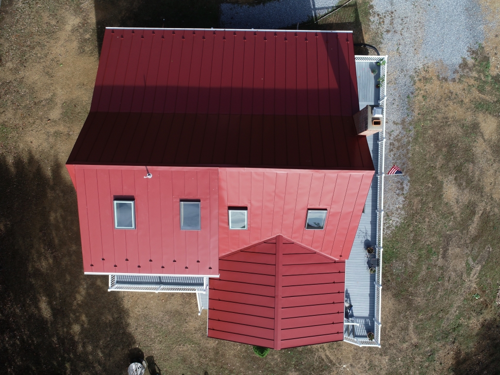 Red metal roofed house with skylights and gutters from above