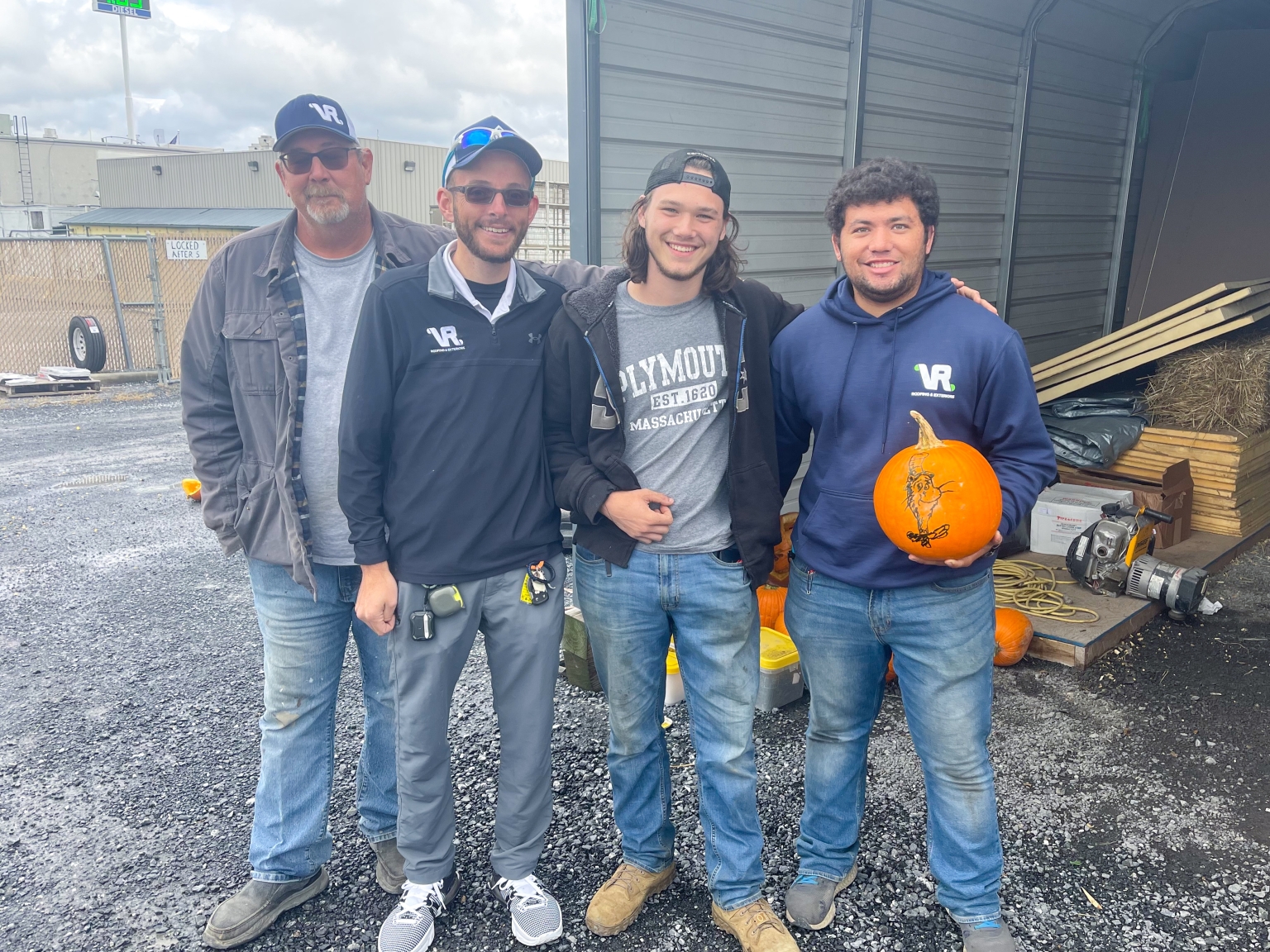 Staff members holding pumpkins and smiling at quarterly meeting