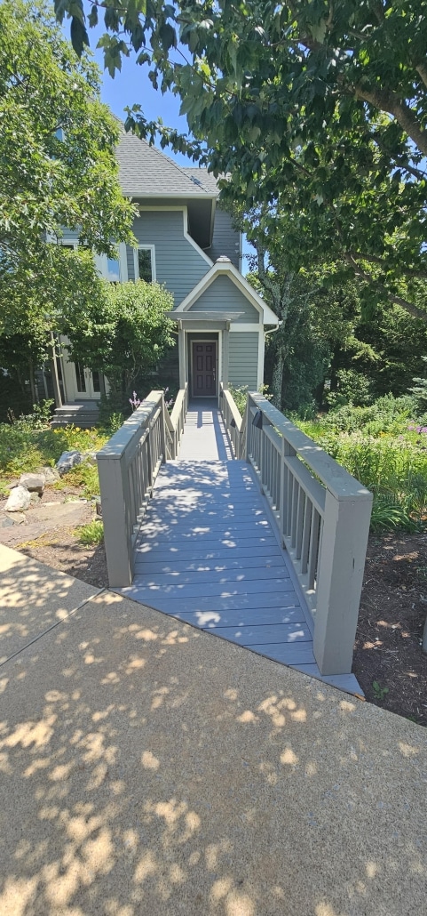 deck boards with railing leading to a home